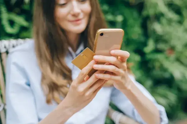 usuaria de celular comprando en internet de manera alegre